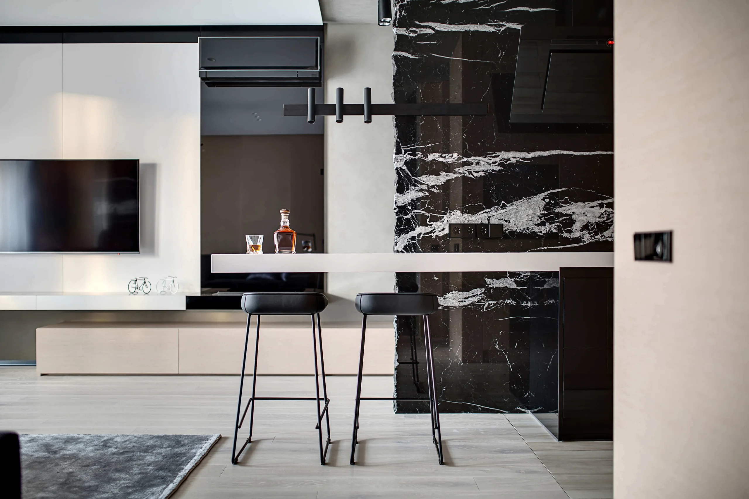 Contemporary bar and lounge inspiration with bold black stone, white veining and slim dark stools