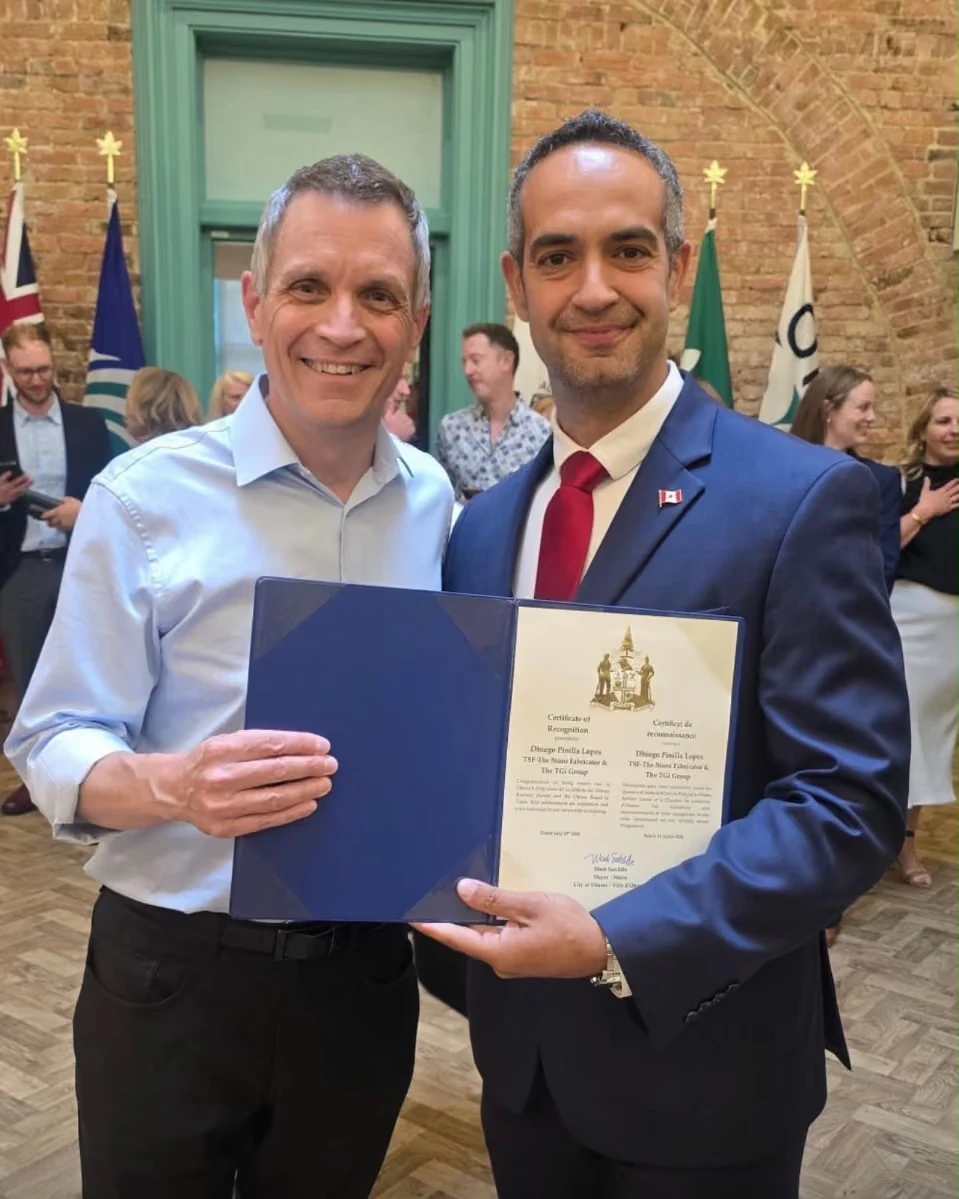 Dhiego Lopes holding a certificate of recognition alongside an Ottawa representative