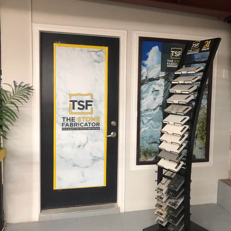 TSF floor-standing rack displaying stone samples beside TSF signage